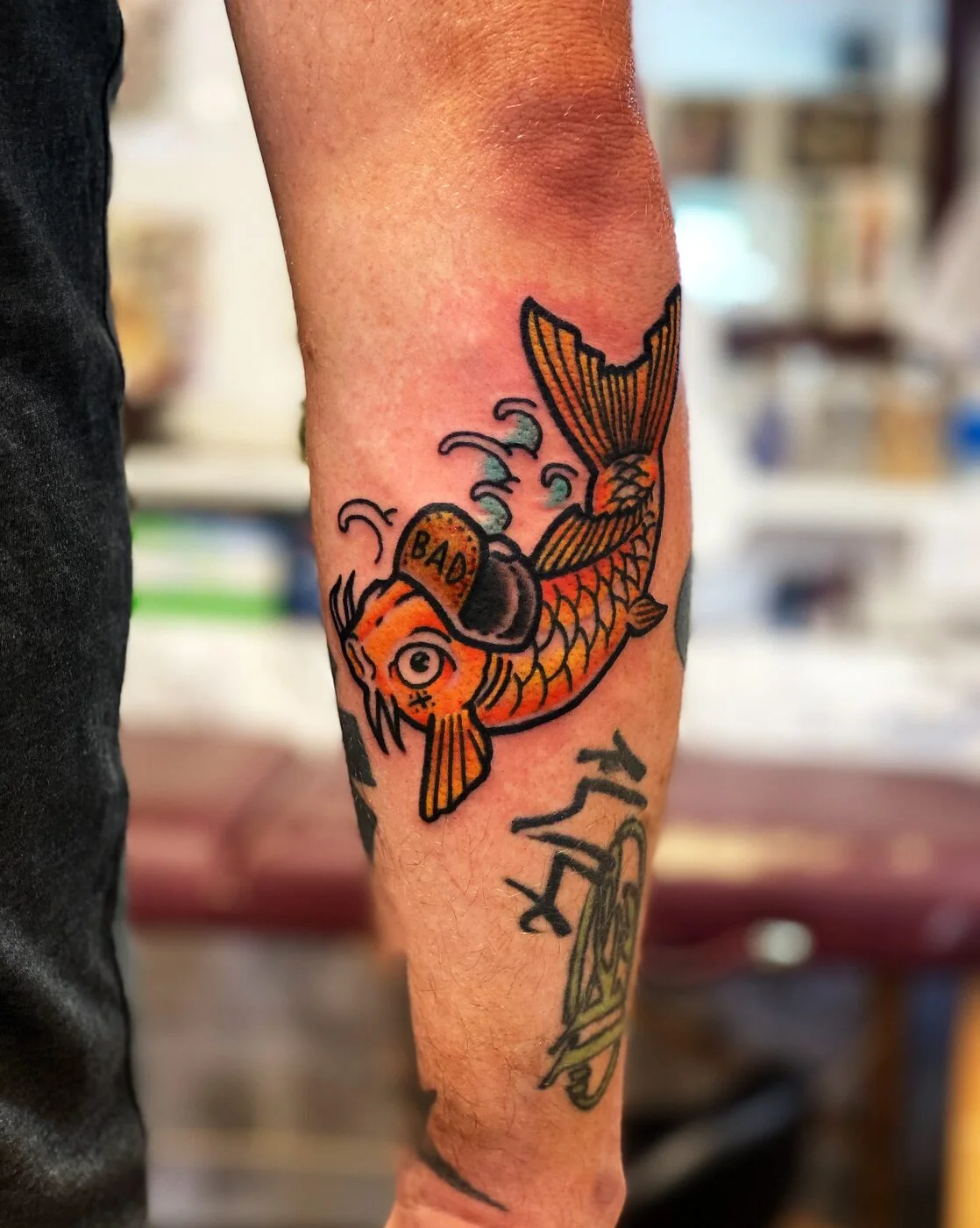American Traditional koi fish with BAD baseball cap tattoo on calf by 2bit (Chris Curren) at Lost at Sea Tattoo, Chinatown, Honolulu American Traditional koi fish with BAD baseball cap tattoo on calf by 2bit (Chris Curren) at Lost at Sea Tattoo, Chinatown, Honolulu