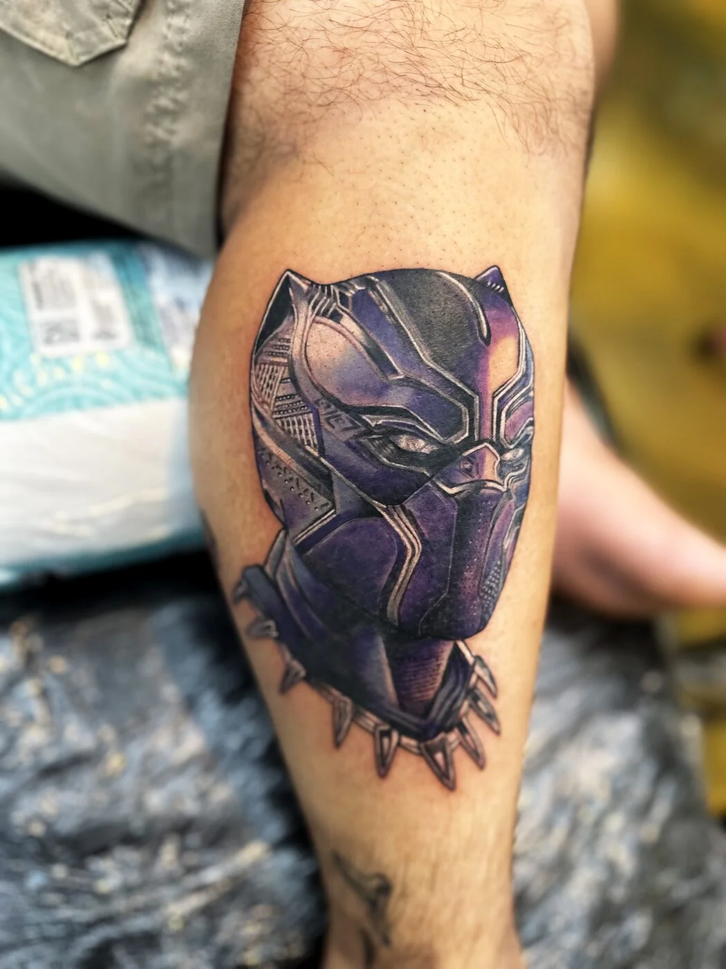 Color Realism Black Panther superhero mask with shoulder armor tattoo on calf by 2bit (Chris Curren) at Lost at Sea Tattoo, Chinatown, Honolulu Color Realism Black Panther superhero mask with shoulder armor tattoo on calf by 2bit (Chris Curren) at Lost at Sea Tattoo, Chinatown, Honolulu